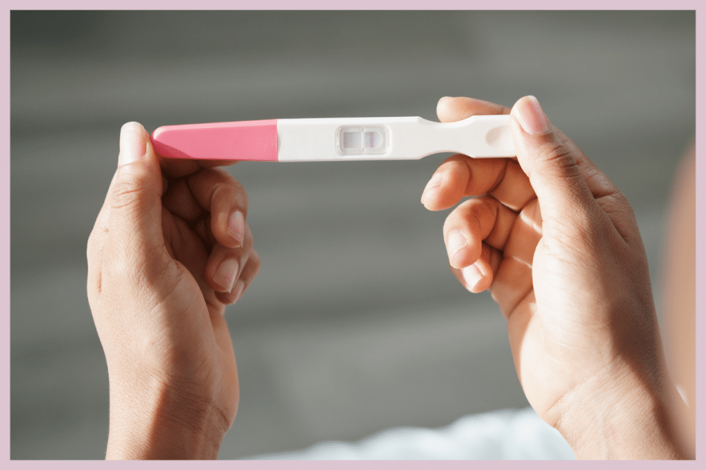 Manos sosteniendo test de embarazo positivo